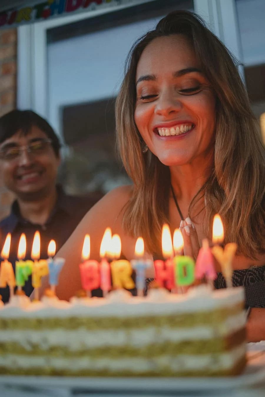 Mujer soplando las velas de una torta de cumpleaños
